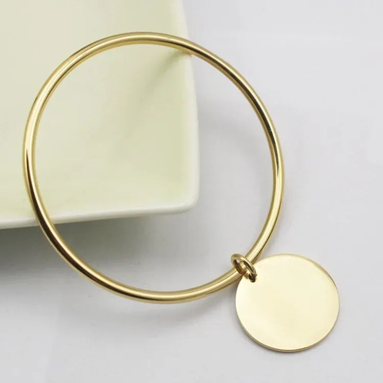 Bangle bracelet with golden charms in stainless steel