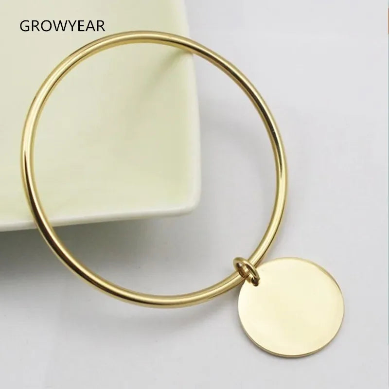Bangle bracelet with golden charms in stainless steel