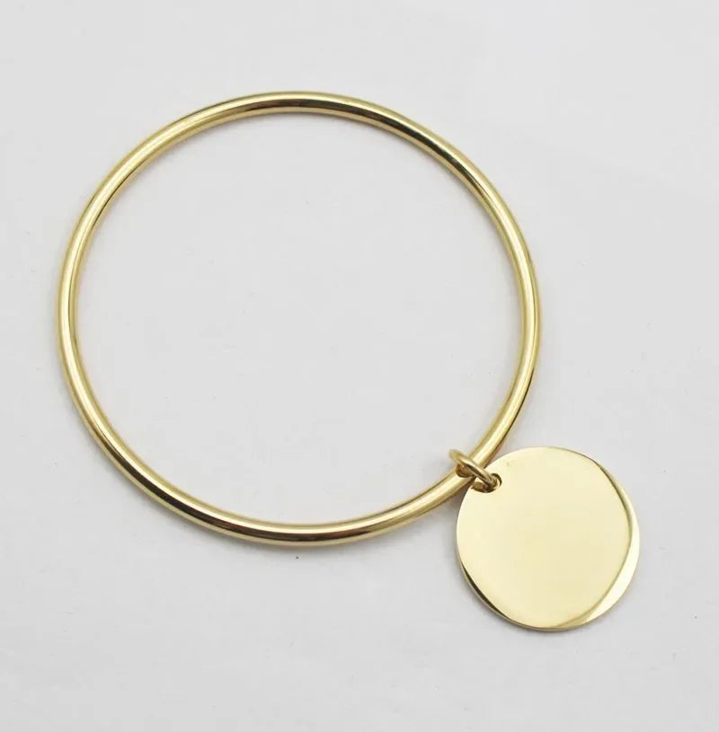 Bangle bracelet with golden charms in stainless steel